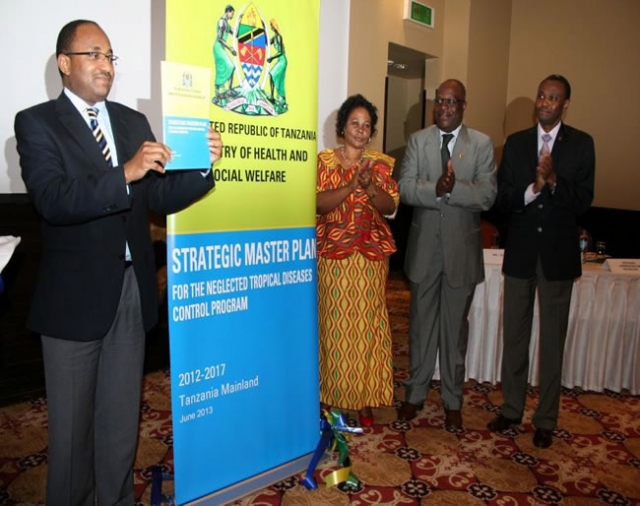 The Minister of Health and Social Welfare, Hon. Dr. Hussein Mwinyi holding the launched national master plan for NTD control and elimination