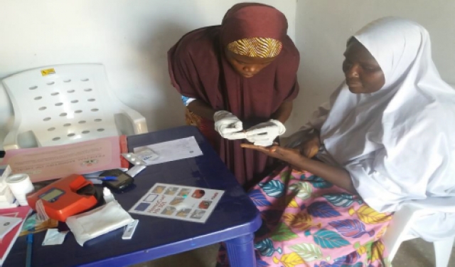 Midwife doing routine malaria Rapid Diagnostic Test (RDT) screening to a pregnant woman as an Ante-Natal Care service in Garba Buzu IDP Camp MdM