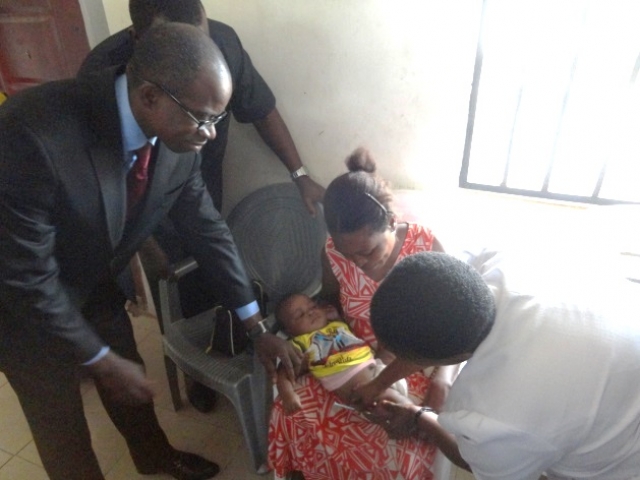 The permanent secretary of Abia State ministry of health supporting a health worker to vaccinate a 14-week-old baby with IPV