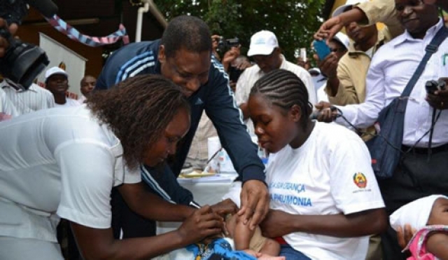 Minister of Health, Dr. Alexandre Manguele, giving the first PCV-10 vaccine to 2-months old Omar Octavio