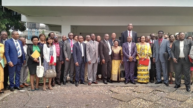 Photo de famille comprenant le Représentant de l’OMS en RDC, le Secrétaire général à la Santé Publique, l’ancien Basketteur de la NBA, Mutombo DIKEMBE et les autres participants à la réunion conjointe sur la lutte contre le cancer du col de l’utérus en RDC, devant la salle de conférence de l’OMS, à Kinshasa