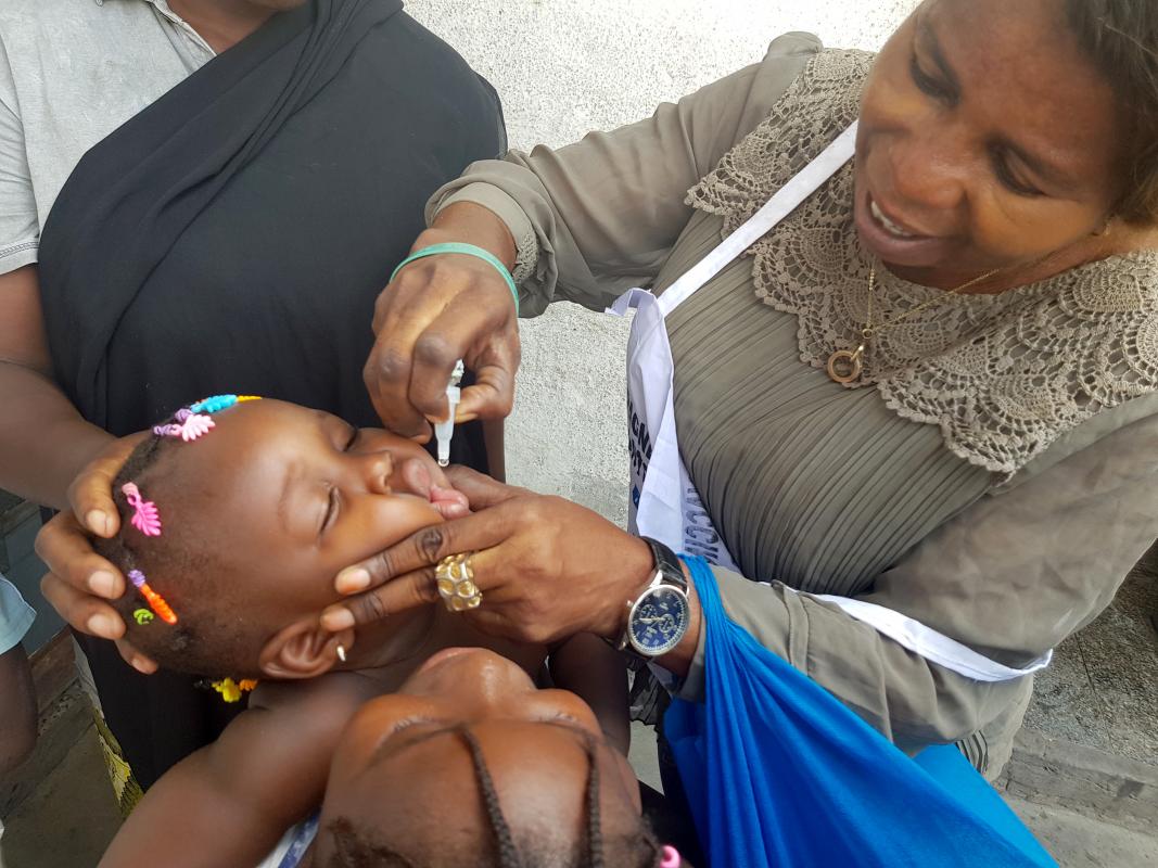 Une vaccinatrice donnant le vaccin oral polio bivalent à un enfant - dans la zone de santé de Kasa-vubu, à Kinshasa. OMS/Eugene Kabambi