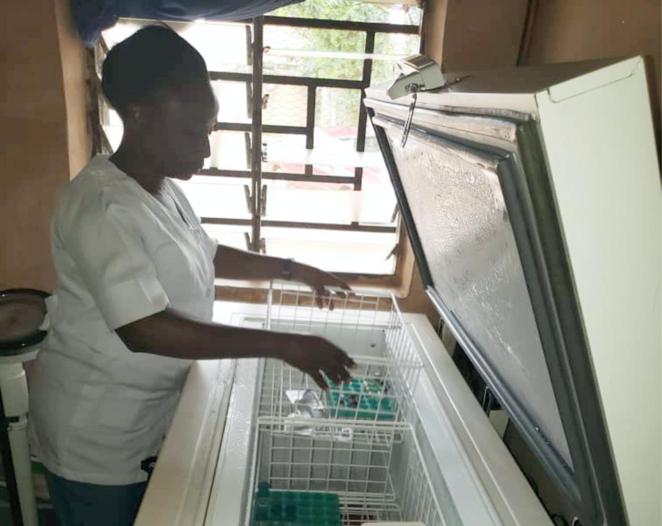 Nurse Ayenajeh Sasefu carefully arranges vaccines for various diseases