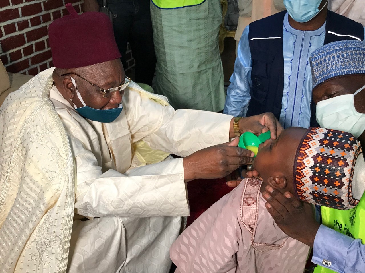 Shehu of Borno administers malaria chemoprevention drug to his grandson.