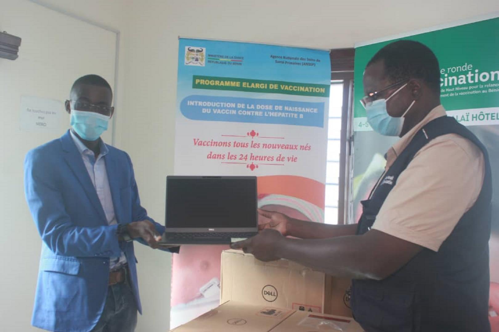 (De la droite vers la gauche) Dr Aristide Roch SOSSOU, Conseiller NPO/IVD, chargé de la Vaccination à l’OMS remettant au nom du Représentant Résident p.i. de l’OMS, un lot d’ordinateurs au Dr KAUCLEY Landry, Directeur de la Vaccination et de la Logistique représentant la Directrice générale de l’Agence Nationale des Soins de Santé Primaires.