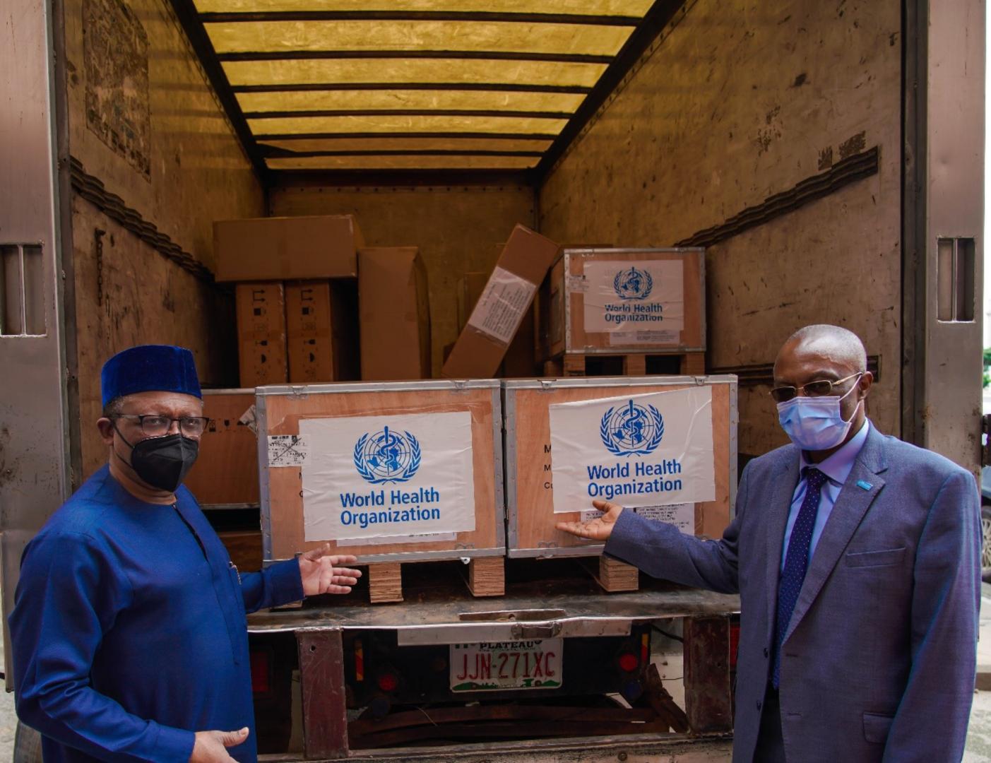 The Minister (left) and WR showing some containers of the donated ventilators to journalists present at the hand-over ceremony.jpg 