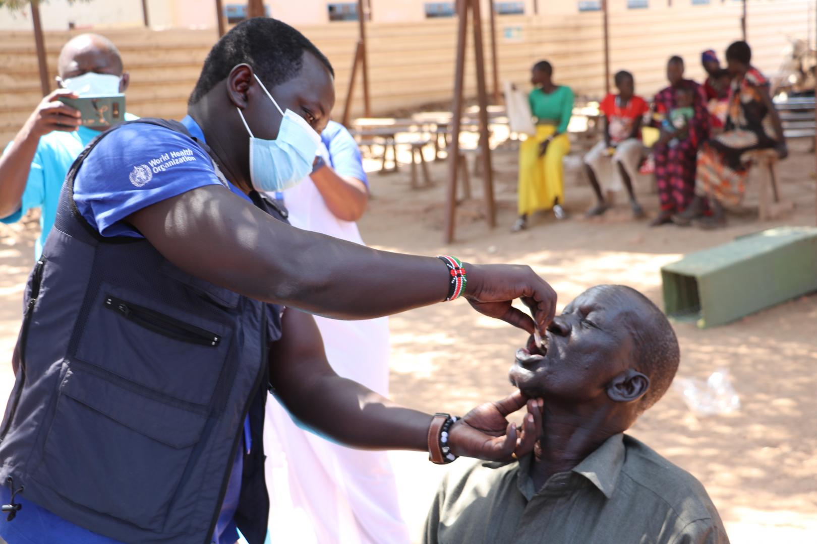 WHO’s Dr Abraham Abenego administering oral cholera vaccine 