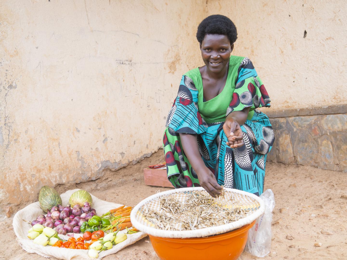 Marie Jeanne sits outside selling fruits and vegetables