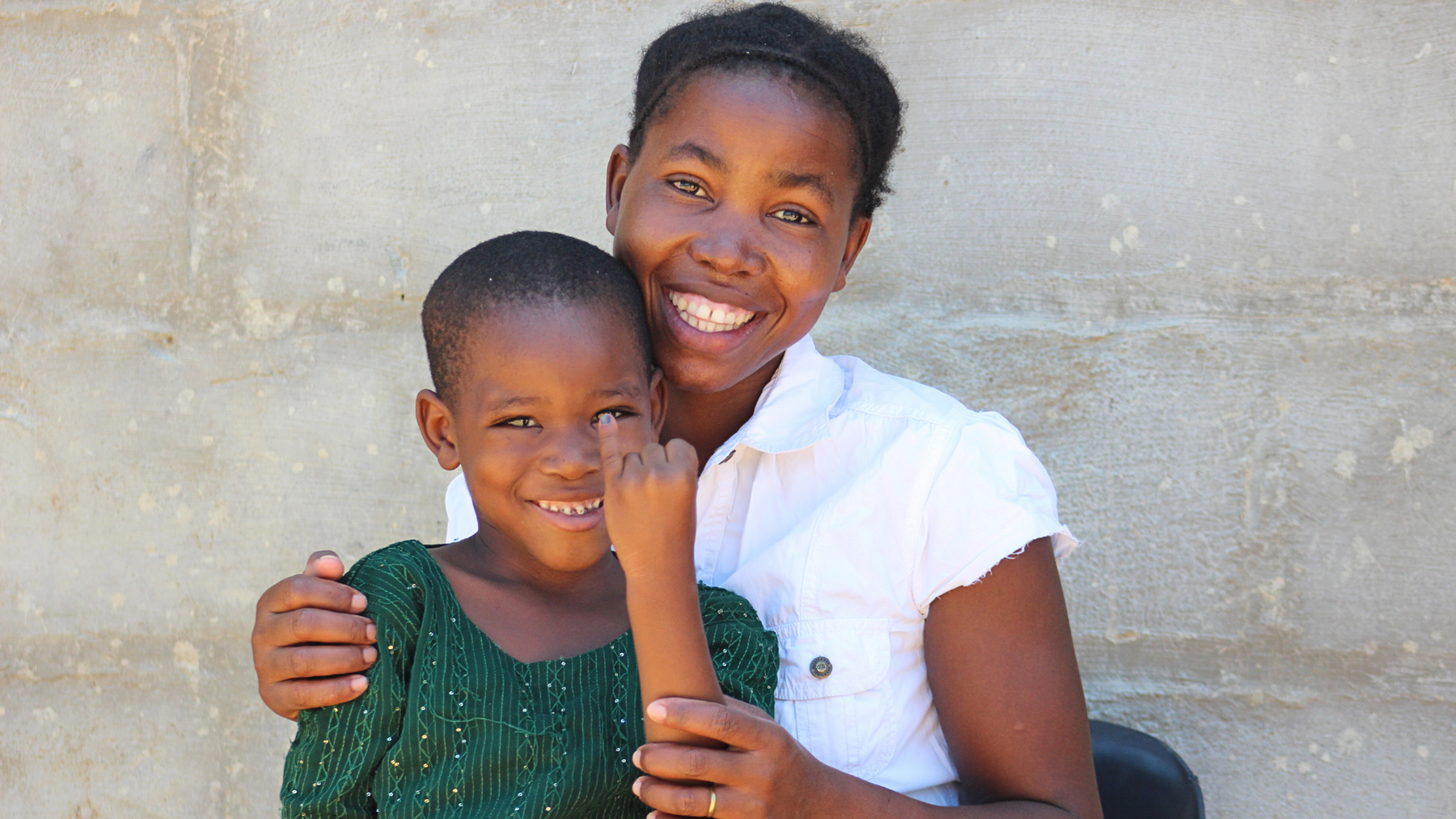 Elizabeth, a 7-year-old girl from Dukwi Refugee Camp in Botswana shows her marked finger after receiving her polio vaccine.