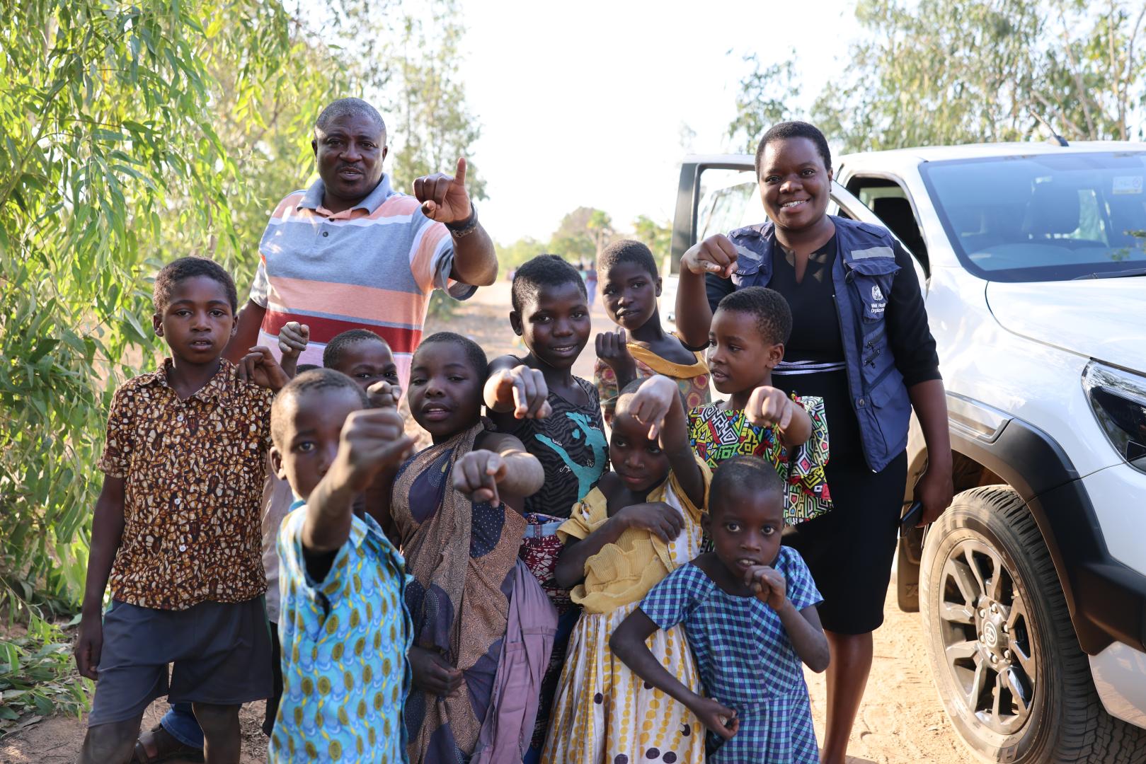 Vaccinated children showing off their marked figures