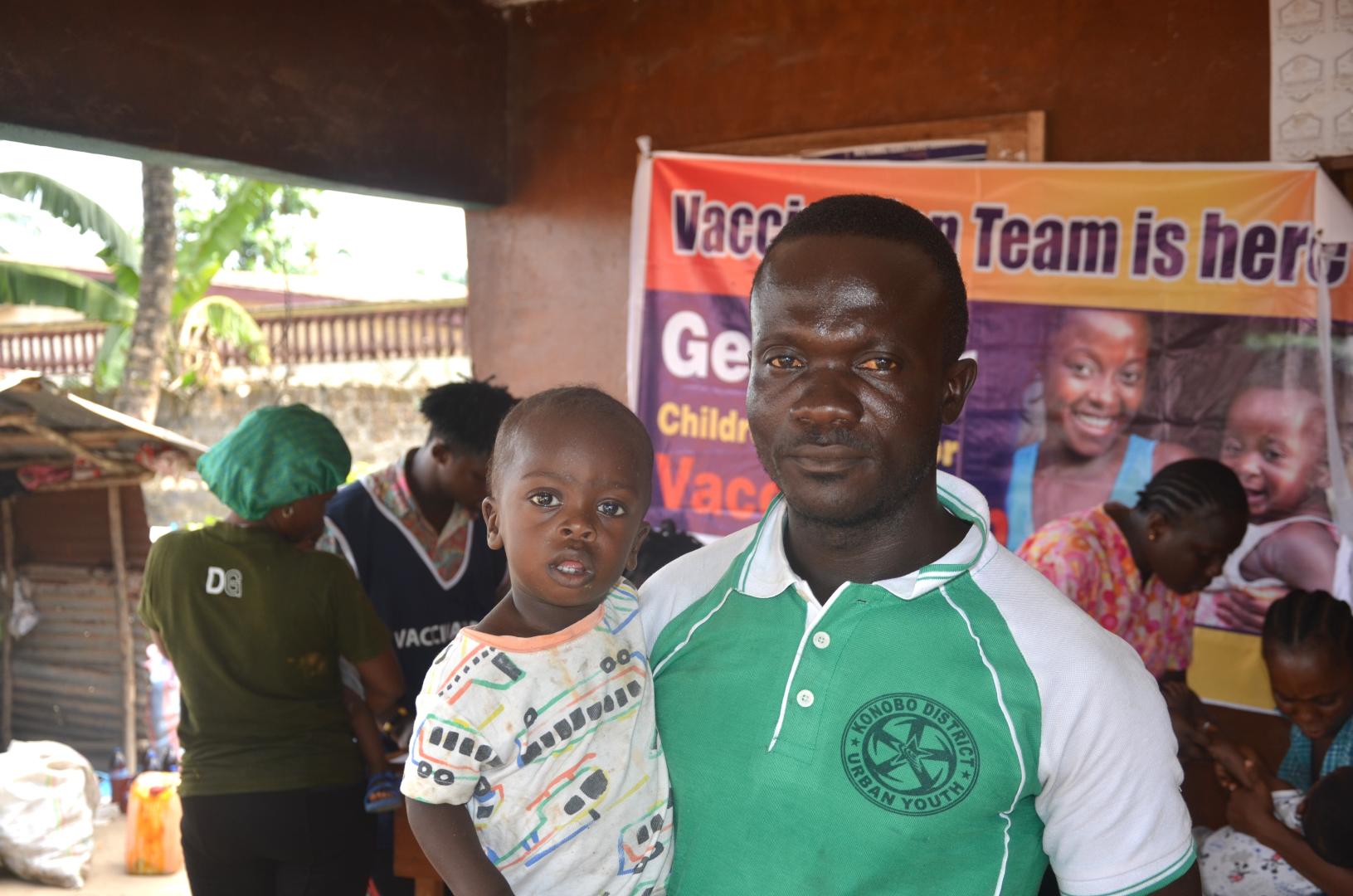 hedrick Barlee, with his one-year-old son Blessed Barlee, at the vaccination campaign