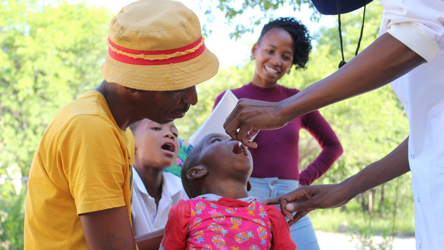 A father watches as his daughter receives the polio vaccine during the polio supplementary vaccination campaign in Sowa town, February 2023.