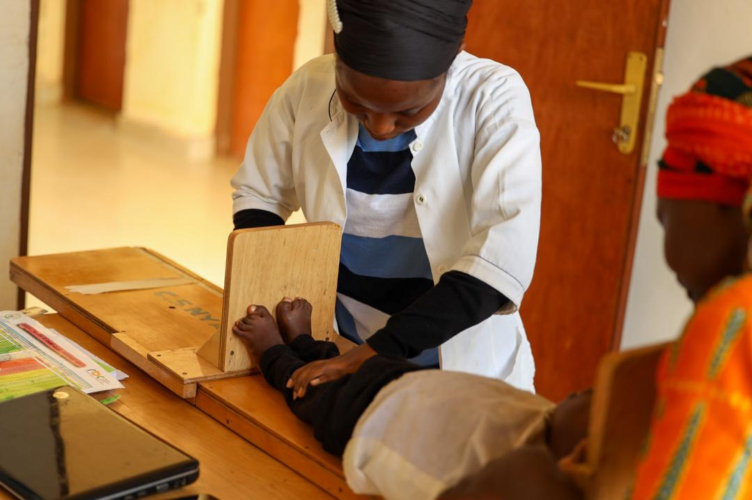 Mado Ishimwe, a nutritionist in Ntangazwa, taking measurements of a child 