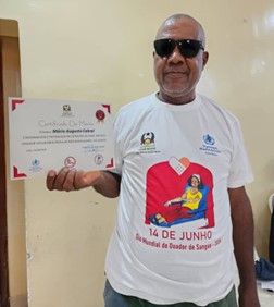 Legenda: Mário com o seu certificado de mérito na categoria Ouro durante a comemoração do Dia Mundial do Doador de Sangue, 14 Junho 2024