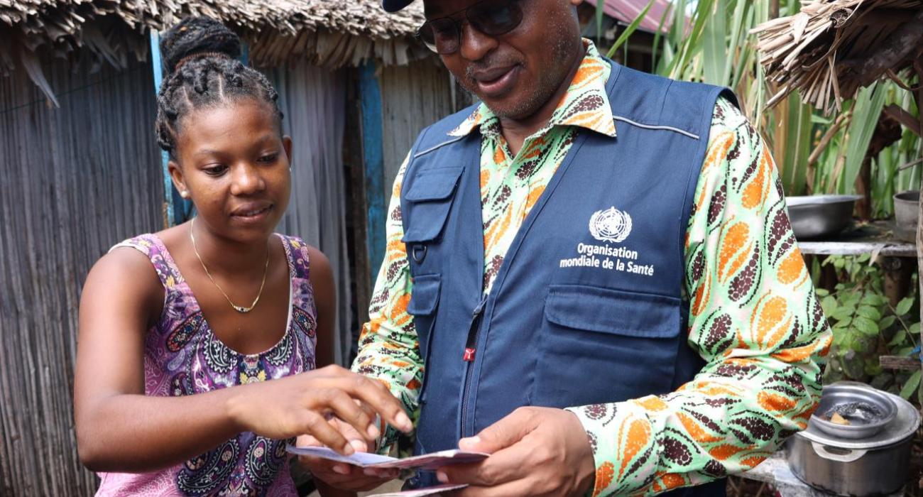 Jacqueline tout heureuse expliquant au Représentant de l'OMS Madagascar, ses avantages avec le projet de la CSU.