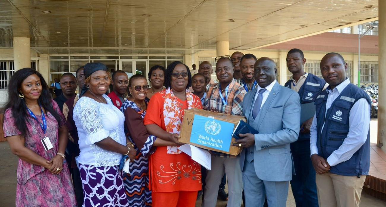 Dr Catherine Cooper, representing the Ministry of Health receiving the donation from WHO Rep, Dr Clement Peter.