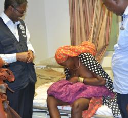 Teenage girl breastfeeding her newborn baby while WHO Representative, Dr  Charles Sagoe-Moses and Mr Thomas Shapumbu, Kunene Regional Health Director looks on