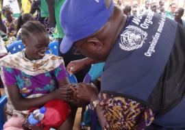 Dr Bimpa Lupanzula, gives an anti-polio drop to a child during the campaign launch at Jebel Dinka