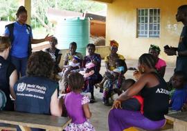 Ebola outbreak in Sierra Leone: WHO staff talking to mothers in Sierra Leone on getting children to health care.