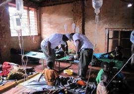 WHO Representative for Tanzania with the medical doctor in charge reviewing a severely dehydrated patient at the CTC at Nyarugusu