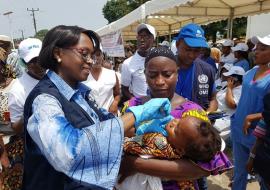 Dubreka La Directrice régionale de l'OMS vaccinant un enfant contre la Polio