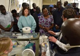 The Minister of Health Dr Aceng (Purple outfit) and the WHO representative Dr Jack Abdoulie (black outfit) listen to Dr Thomas Strecker from WHO during the commissioning of the mobile laboratory at Kapchorwa District Hospital 