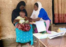 Miriam, a community health worker, diagnoses a sick child and provides treatment medicines/ Photo: WHO/C. Kane