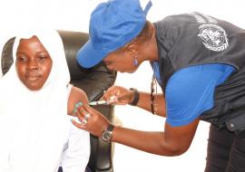 WHO staff vaccinating a girl during the occasion.