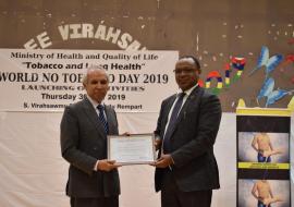  Dr Hon Anwar Husnoo, Minister of Health and Quality of Life receiving the ‘Certificate of Appreciation’ from Dr Laurent Musango, WHO Representative in Mauritius on behalf of Dr Tedros, Director General and Dr Moeti, Regional Director of the World Health Organization during the celebration of the World No-Tobacco Day 2019