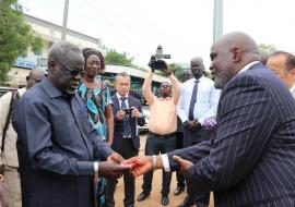 Dr Olu handing over the keys to Honorable Minister for Health, Dr Riek Gai Kok