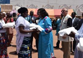 Le Ministre de la santé, Pr Léonie Claudine Lougué/ Sorgho( Robe bleue)  remet ici une MILDA à une femme et par la même occasion la sensibilise sur l’utilisation de la MILDA