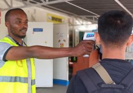 Primary screening includes temperature measurement and visual observation of travelers to look for signs of illness. © WHO/Tania Seburyamo  