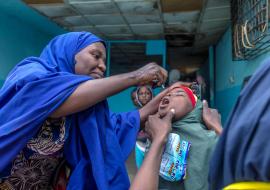 A vaccinator provides a young girl with an oral polio vaccine in Kano State, Nigeria, 2020