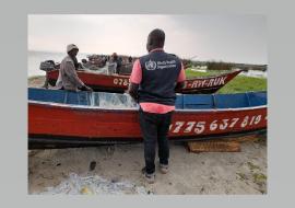 WHO field team member talks to one of the fishermen at Rwemanja Landing site 