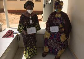 Madame Amie Jobe and one of her daughters, a medical Doctor, diplaying their vaccination cards, after receiving the COVAX vaccine