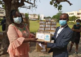 (De droite à gauche) Dr GLELE KAKAI Clément, Conseiller IHM, chargé des Urgences Sanitaires à l’OMS remettant un échantillon d’intrants sanitaires à Dr Armande Mathilda Eléonore GANDJETO, Directrice Adjointe du Cabinet du Ministère de la Santé