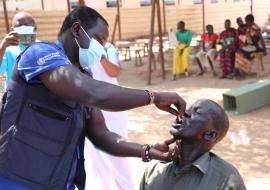 WHO’s Dr Abraham Abenego administering oral cholera vaccine 