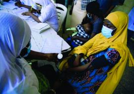 A health worker checking a patient’s blood pressure