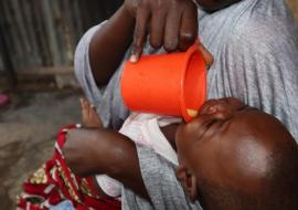 Hajara a caregiver, administering malaria drug to her eligible child