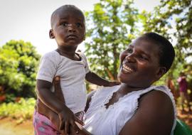 A happy mother near Lilongwe smiles relieved after getting her child vaccinated against polio