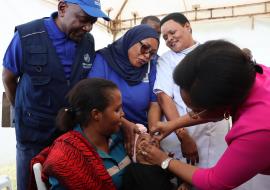 Professor Tumaini Nagu, Chief Medical Officer giving a dose of measles vaccination 