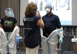 WHO facilitator leading a session on donning and doffing of personal protective equipment(PPE)