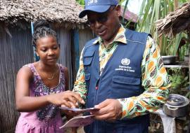 Jacqueline tout heureuse expliquant au Représentant de l'OMS Madagascar, ses avantages avec le projet de la CSU.