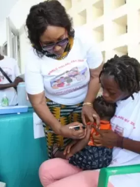 Health Minister Dr. Louise Kpoto administers the first Malaria Vaccine 