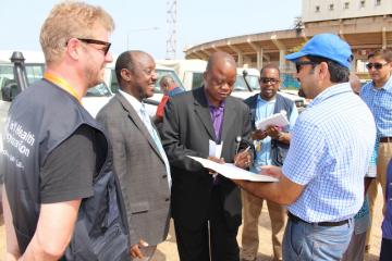 The Deputy Minister of Health (Administration), Hon. Mathew T.K. Flomo ( 2nd from right) signing the certificate of transfer of vehicles in the presence of the WHO Representative, Dr. Alex Gasasira (second from left)