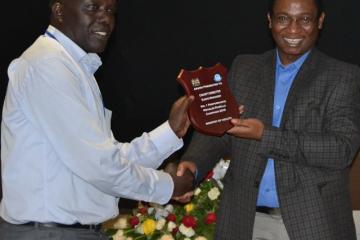 Elgeyo Marakwet director Mr William Kendago receives best award for county immunization performance  from Dr Jackson  Kioko, DMS