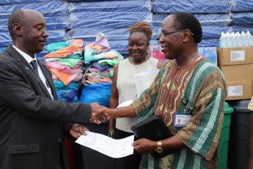 Dr Alex Gasasira handing over a consignment of assorted items for E.S Grant Hospital to Dr Francis Kateh, Deputy Minister of Health/CMO. Looking on is Mrs. Cooper, the Hospital administrator