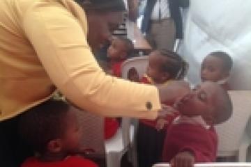 Dr Fiona Braka administering polio drops to a young boy at the NID launching event.