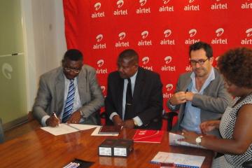 Dr Eugene Nyako, left signing the MOU for the Ebola Virus Disease hotlines