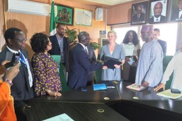 Permanent Secretary Ministry of Foreign Affairs Ambassdor Bulus Lolo exchanging signed documents with German KfW representative Dr Marga Kowalewski while WR representative Dr Rex Mapzanje (on the left) looks on